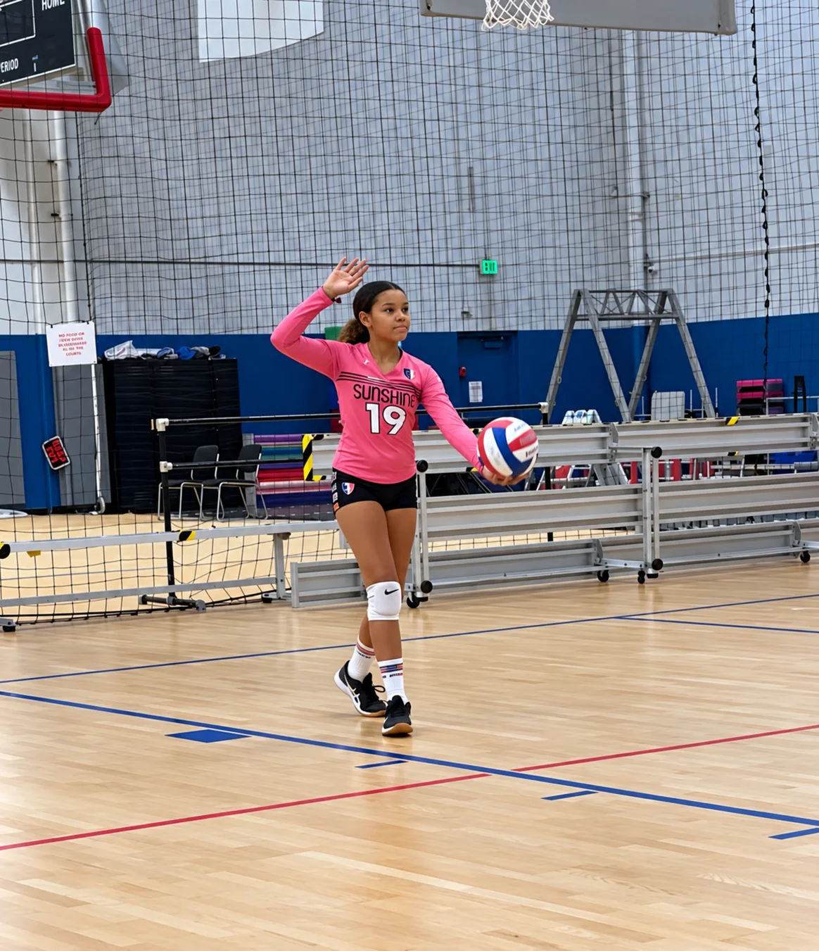 Eva preparing to serve on a volleyball court